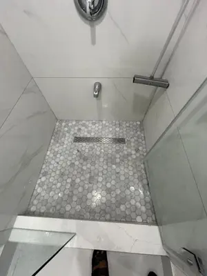 a bathroom with a shower with a tiled floor at V-Swim Suite-2 in Toronto