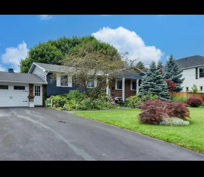 a house with a driveway in a residential neighborhood at Grimsby Lakeside Vacation Home in Grimsby