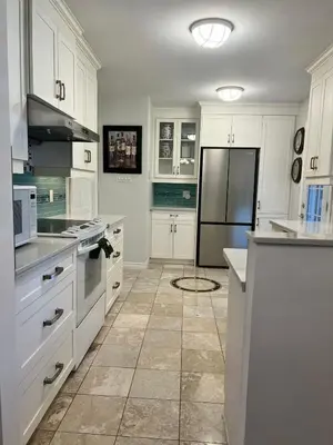 a kitchen with white cabinets and a black refrigerator at Grimsby Lakeside Vacation Home in Grimsby