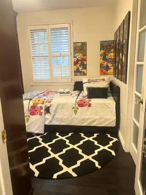 a bedroom with a bed with a black and white rug at Grimsby Lakeside Vacation Home in Grimsby