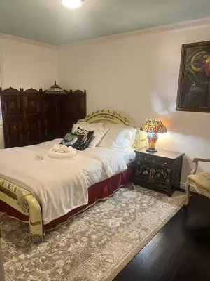 a bedroom with a bed and a table with a lamp at Grimsby Lakeside Vacation Home in Grimsby