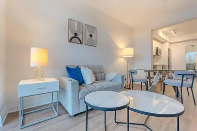 a living room with a couch and two tables at RivetStays - The Westmounts in Toronto
