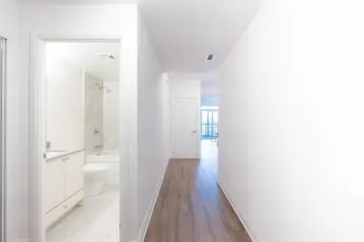 a white bathroom with a toilet and a sink at RivetStays - The Westmounts in Toronto