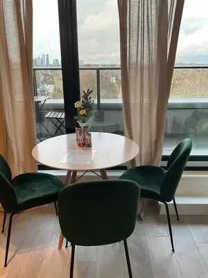 a table and chairs in a room with a window at Serene Cozy 1BDRM Condo near Sherway Mall, Lakeshore, & Airport in Toronto