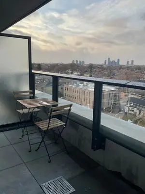a balcony with two tables and a view of a city at Serene Cozy 1BDRM Condo near Sherway Mall, Lakeshore, & Airport in Toronto