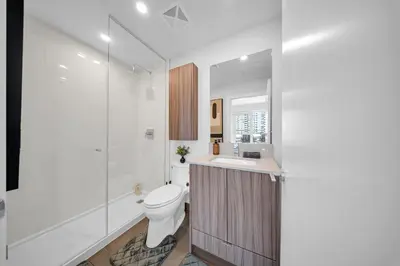 a bathroom with a toilet and a sink and a shower at The Grand Aurelia Suites - Mississauga City Center in Mississauga
