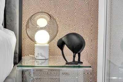 a black cat statue on a glass table next to a wall at The Grand Aurelia Suites - Mississauga City Center in Mississauga