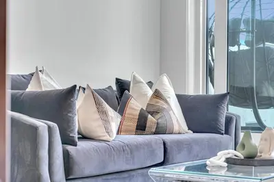 a gray couch with pillows on it in a living room at The Grand Aurelia Suites - Mississauga City Center in Mississauga
