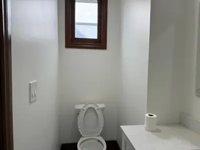 a white bathroom with a toilet and a window at Downtown Residence Room 3 in Guelph