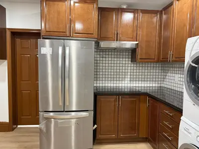 a kitchen with wooden cabinets and a stainless steel refrigerator at Downtown Residence Room 3 in Guelph