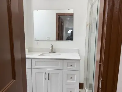 a white bathroom with a sink and a mirror at Downtown Residence Room 3 in Guelph