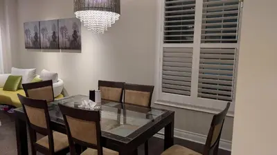 a dining room with a glass table and chairs at Bright ensuite with WiFi Parking available in Markham