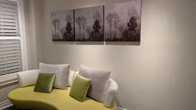 a living room with a yellow couch with four pillows at Bright ensuite with WiFi Parking available in Markham