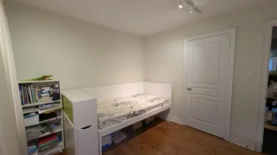 a small bedroom with a bed and a book shelf at Bright ensuite with WiFi Parking available in Markham
