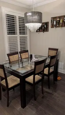 a dining room table with chairs and a chandelier at Bright Bedroom with Shared bathroom and WiFi Parking available in Markham