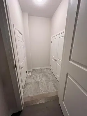 a hallway with white doors and a tile floor at AyrHaus- Modern Comfort Meets Small-Town Charm
