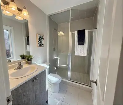 a bathroom with a sink and a toilet and a shower at AyrHaus- Modern Comfort Meets Small-Town Charm