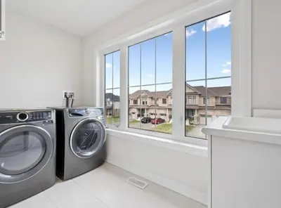 a laundry room with a washing machine and a window at AyrHaus- Modern Comfort Meets Small-Town Charm