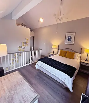 a bedroom with a bed and two tables and two lamps at Slopeside Loft at North Creek Resort in Blue Mountains