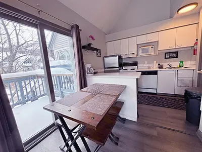 a kitchen with a table and a large window at Slopeside Loft at North Creek Resort in Blue Mountains