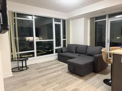 a living room with a couch and large windows at The greatest views in the heart of Mississauga in Mississauga
