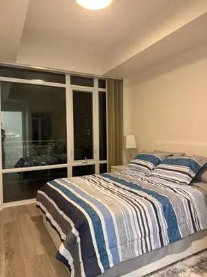 a bedroom with a bed and a large window at The greatest views in the heart of Mississauga in Mississauga