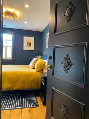 a bedroom with blue walls and a bed and a door at Hattan House Boutique Hotel Bed & Breakfast in Niagara on the Lake