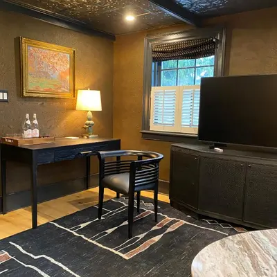 a room with a desk and a chair and a television at Hattan House Boutique Hotel Bed & Breakfast in Niagara on the Lake