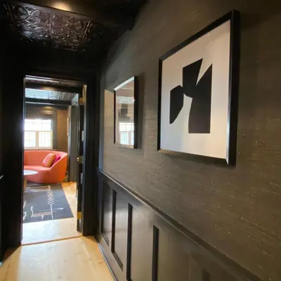 a hallway leading to a living room with a orange couch at Hattan House Boutique Hotel Bed & Breakfast in Niagara on the Lake