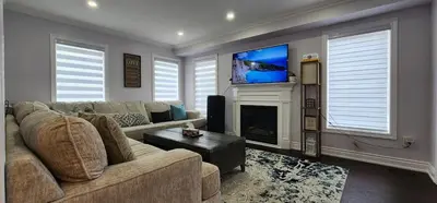 a living room with a couch and a flat screen tv at Modern Cozy Nook in Brampton
