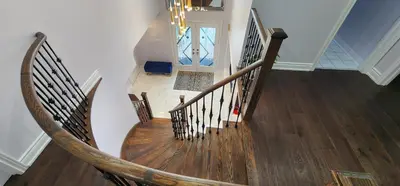 a spiral staircase in a home with wooden floors at Modern Cozy Nook in Brampton