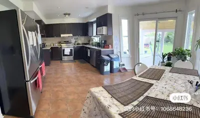 a kitchen with black cabinets and a table in a room at M2 Private cozy bedroom in Mississauga