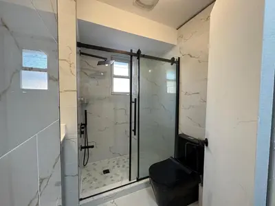 a bathroom with a glass shower with a toilet at StayMaple in Toronto