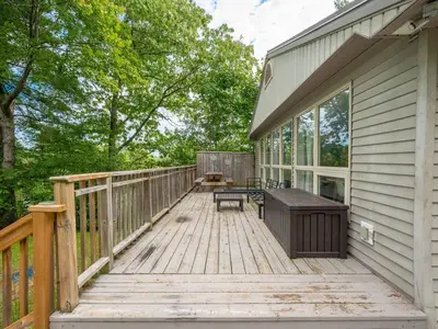 a wooden deck with a bench on the side of a house at Lakefront Muskoka Cottage with Fire Pit and BBQ in Port Carling