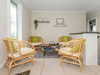 a living room with two chairs and a fireplace at Lakefront Muskoka Cottage with Fire Pit and BBQ in Port Carling
