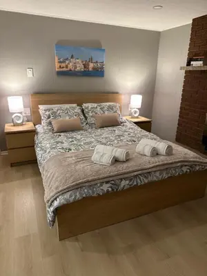 a bedroom with a large bed with two pillows on it at Tamuna studio in Hamilton
