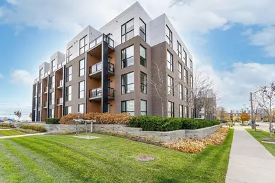 a large apartment building with a lawn in front of it at 1 BR Boutique Charm, Urban Calm! in Oakville