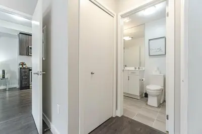 a white bathroom with a toilet and a sink at 1 BR Boutique Charm, Urban Calm! in Oakville