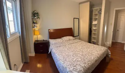 a bedroom with a bed and a lamp and a window at 203 Comfortable private bedroom on second floor in Mississauga