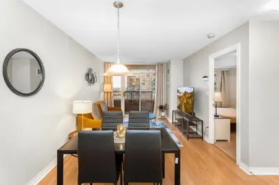a dining room and living room with a table and chairs at High-Rise Skyline Suite Sleeps 5 Steps to SQ1 in Mississauga
