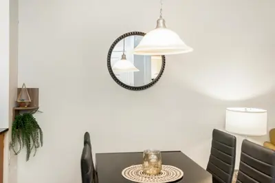 a dining room table with a mirror on the wall at High-Rise Skyline Suite Sleeps 5 Steps to SQ1 in Mississauga