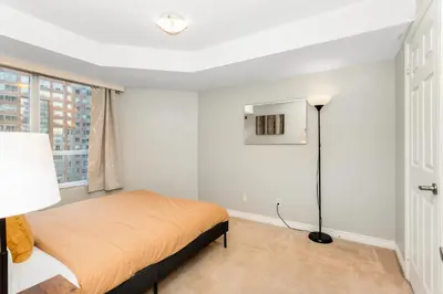 a bedroom with a bed and a window at High-Rise Skyline Suite Sleeps 5 Steps to SQ1 in Mississauga