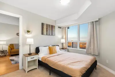 a bedroom with a bed and a large window at High-Rise Skyline Suite Sleeps 5 Steps to SQ1 in Mississauga
