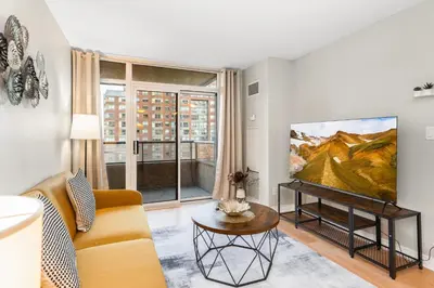 a living room with a couch and a tv at High-Rise Skyline Suite Sleeps 5 Steps to SQ1 in Mississauga