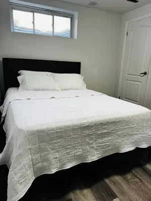 a bedroom with a large white bed with a window at Konia Abode in Orangeville