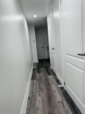 an empty hallway with white walls and wood floors at Konia Abode in Orangeville