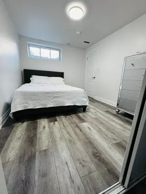a bedroom with a bed and a wooden floor at Konia Abode in Orangeville