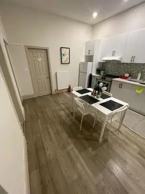 a kitchen with a table and a kitchen with white cabinets at Central Downtown New Year Stay- Self Checkin & Free Wifi in Toronto