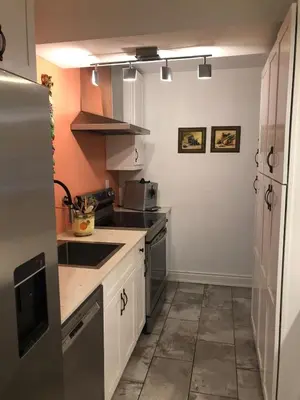 a kitchen with white cabinets and a stove top oven at Hamilton condo, close to Toronto and Niagara Falls in Hamilton