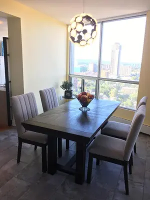 a dining room table with chairs and a large window at Hamilton condo, close to Toronto and Niagara Falls in Hamilton